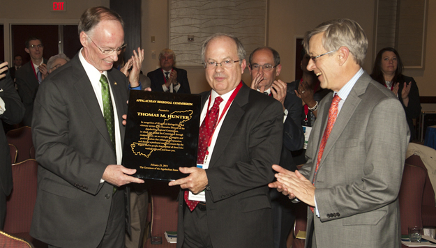 Photo of ARC Executive Director Thomas Hunter receiving a plaque in honor of his service to the Commission and to the Appalachian Region at ARC's February 23, 2014, governors' quorum meeting in Washington, D.C. Shown with Hunter are ARC Federal Co-Chair Earl Gohl (right) and Alabama Governor Robert Bentley.